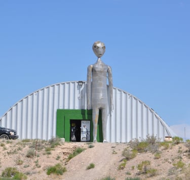 a statue of an alien standing in front of a building