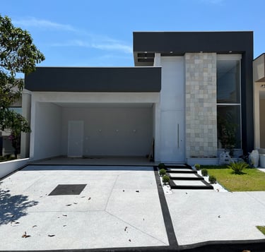 Fachada de sobrado moderno com garagem frontal e projetos estruturais integrados.