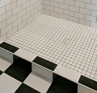 a bathroom with a black and white tiled floor