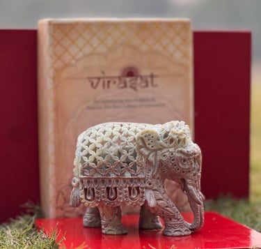 a small elephant statue sitting on a red book