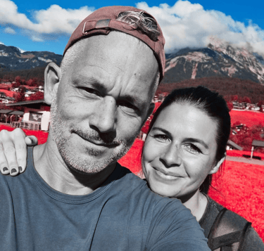 a man and woman taking a selfie in a red - hued photo
