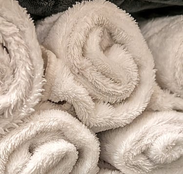 rolled white towels stacked 