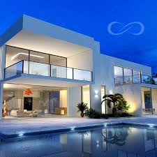 Villa de luxe moderne de nuit à Kribi avec piscine et éclairages intérieurs chaleureux.