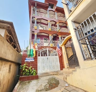 Immeuble d'appartements avec balcons en fer forgé et portail décoratif blanc. Yaoundé nsam