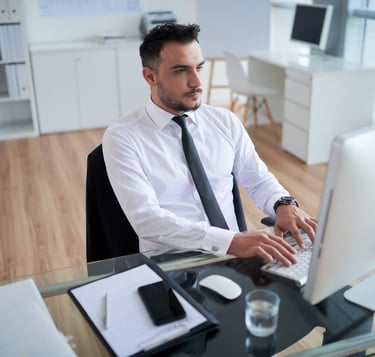 a man in a white shirt and tie is sitting at a desk
