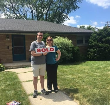Proud couple in front of a home after financing energy efficient upgrades 