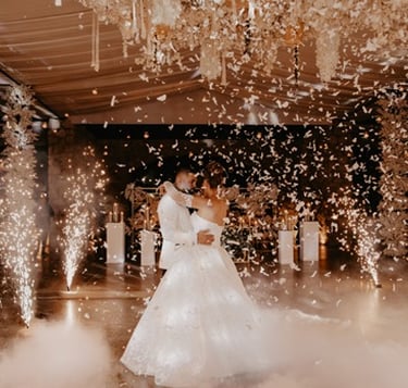 Novios bailando el vals el día de su boda rodeados de mariposas de papel y pirotecnia fria muy feliz