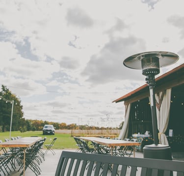 a patio with a table and chairs and a propane heater