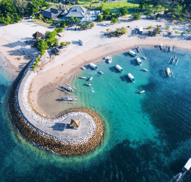 a beach with boats and blue water
