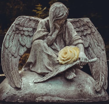 One angel in stone with a white rose. Julia Kadel-unsplash