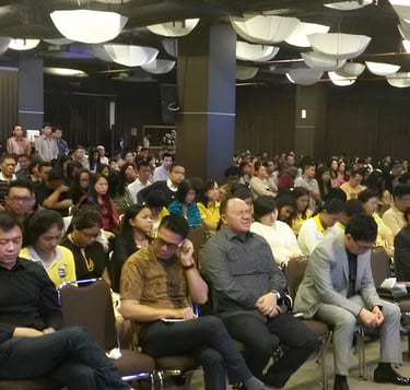 a large group of people sitting in chairs in a room