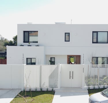 Una casa blanca con un área cercada de color blanco.