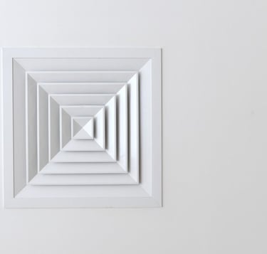 Grille de ventilation naturelle carrée au plafond, idéale pour une aération discrète et passive.