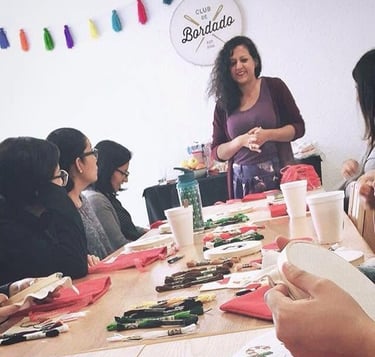 Un grupo de mujeres participa en un taller de bordado del Club de Bordado, utilizando hilos colorido