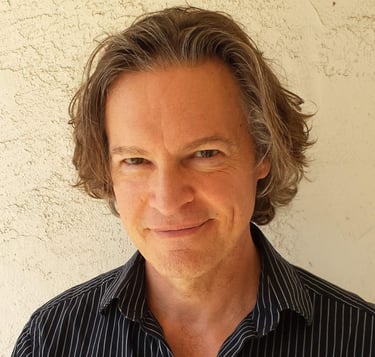 Headshot of Todd Long smiling with medium-length hair
