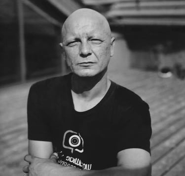 Bald man with black t-shirt looking at camera