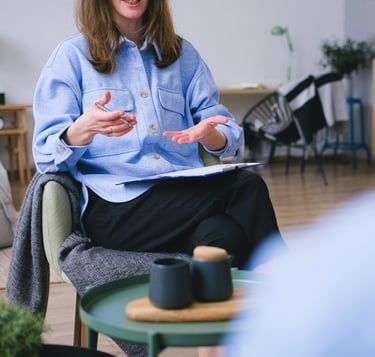 A person sitting in a chair with a notebook offering guidance