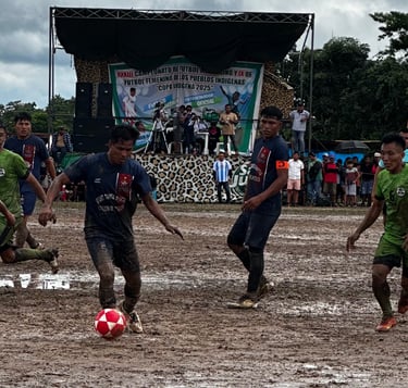 Indigenous soccer tournament players competing on a muddy field during the Copa Indígena 2025.