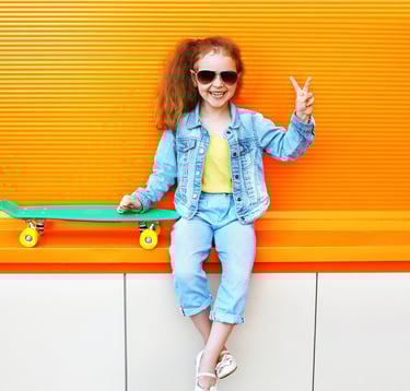 LIttle girl with stylish sunglasses holding up a peace sign