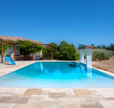 Swimming pool with beach chairs, wide view and waterfall cascade built-in at Domaine Des Lucques