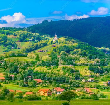 Prekrasan pogled na krajolik Zagorja. U brdima se vide malene kućice i crkva.