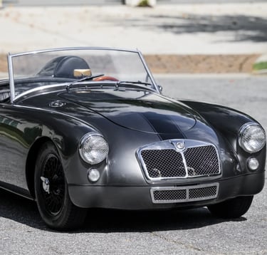 3/4 profile view of a silver 1958 MG MGA Roadster.