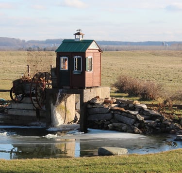 Lac artificiel et paysagement avec chute et champ