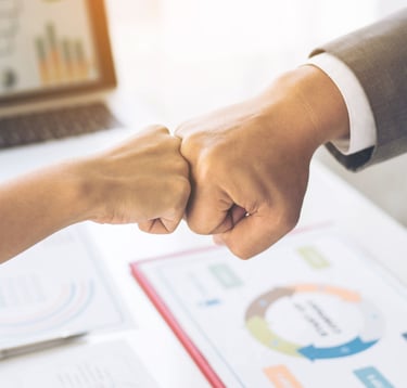Un puño de un hombre y una mujer chocando en forma de trabajo en equipo