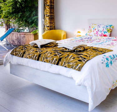 Bed with full bedding, floating bed with two with swimming pool in flower colours at Domaine Des Lucques