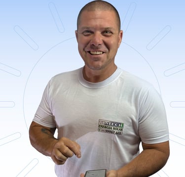 Proprietário da empresa mexendo no celular e de camisa branca com a logo da Vintech no peito.