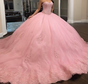 a white wedding dress with pink flowers on a mannequin