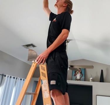 Mick is standing on a ladder doing a custom ceiling repair after water damage