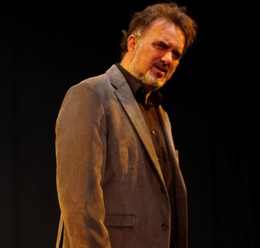 a man in a suit and tie is standing in front of a black background