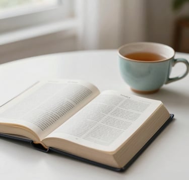 A minimalist, high-key close-up of an open Bible next to a ceramic cup of tea on a clean white table. Soft natural window light creates a warm and spiritual atmosphere. Subtle teal blue accents (#2E7D8C) in the mug's glaze. Clean and modern.