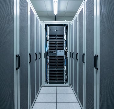 An interior photography shot of a secure, high-density server hall in Western Europe. The rows of hardware are organized with perfect symmetry, cooled by state-of-the-art systems. The lighting is crisp and cool, featuring light blue and off-white tones.