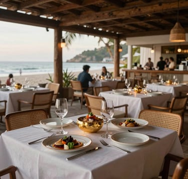 Luxury lifestyle photography showing a gourmet dining experience in an open-air beachfront restaurant in Puerto Escondido. Tables are adorned with fine ceramics and gold accents. Sophisticated ambiance, Latin American / Mexican gastronomy context.