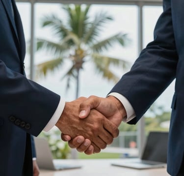 Professional close-up photography of two executives in a handshake, reflecting a successful deal. The setting is a bright, high-profile office in Guanacaste, Costa Rica, with a view of tropical palms through the window. Colors focus on dark navy suits and steel blue surroundings.
