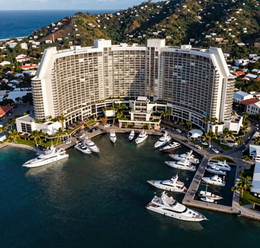 An aerial photography shot of the upscale Flamingo Marina area in Costa Rica, showcasing luxury boats and high-end infrastructure against a backdrop of deep blue ocean and green hills. The composition is clean and technical, emphasizing orderly development and high-value assets.