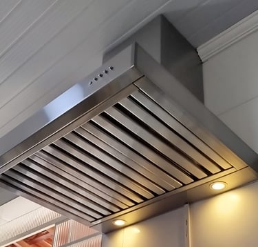 SIlha de cozinha moderna com coifa preta instalada acima de um cooktop a gás embutido