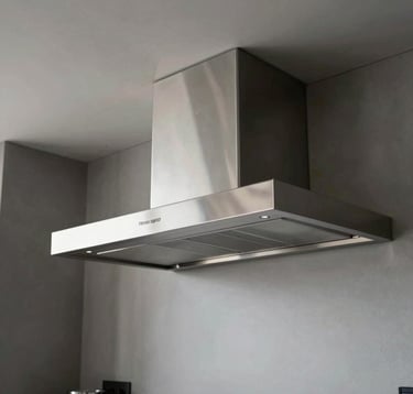 Clean and minimalist interior of a high-end Brazilian apartment. The kitchen features a custom-built stainless steel range hood seamlessly integrated into a graphite ceiling. The atmosphere is sophisticated and ultra-modern.