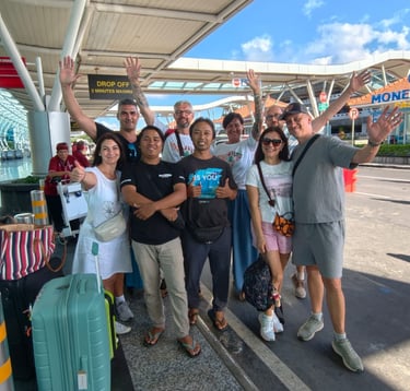Komang with happy customers at the drop-off area of ​​Ngurah Rai Airport, Bali