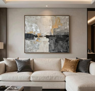 A refined interior shot of a modern penthouse living room. The furniture is upholstered in creamy off-white linens with cushions in warm slate. A large abstract painting in silver-sand and charcoal hangs on a textured wall. The style is sophisticated, tranquil, and high-end.