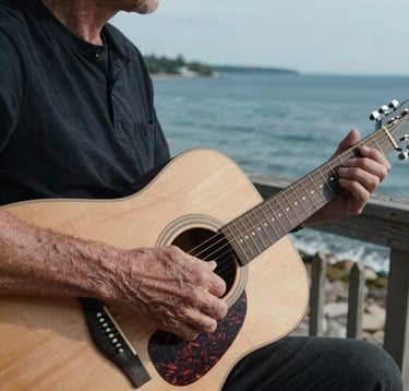 A refined, artistic close-up of weathered hands playing an acoustic guitar on a wooden porch overlooking a calm North American coastal bay. Soft natural light highlights the wood grain of the guitar and the sea spray in the distance. Warm white and deep blue tones.