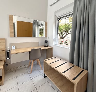 a bedroom with a desk and a bed in the background