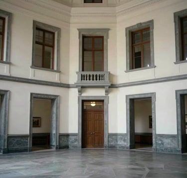 A wide shot of a prestigious research hall with soft off-white walls and architectural details in dark slate grey, conveying a sense of authoritative academic history.