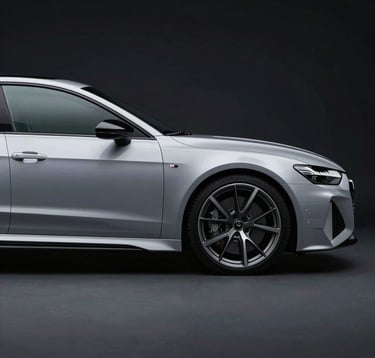 A side profile photograph of a silver Audi RS7 under cool, studio lighting. The car is positioned against a Deep Obsidian Black backdrop, emphasizing its sharp aerodynamic lines and the glint of Cool Slate Grey alloy wheels.