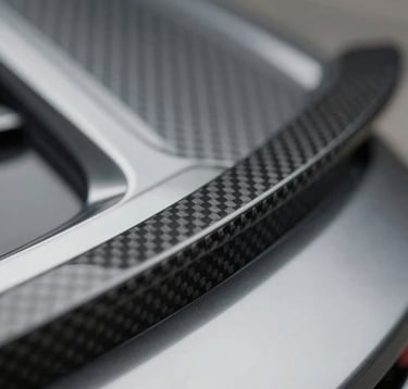 Macro shot of a high-end car transport detail, featuring polished chrome and carbon fiber. Sleek, industrial-luxe style. Palette includes #1A1A1A and #F8F5F0.