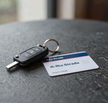 A close-up of a set of premium car keys and an Alta Strada membership card on a minimalist dark stone table. Luxury lifestyle composition with soft natural light.