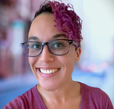 a woman with glasses and a purple shirt