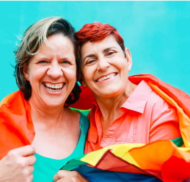 two women in colorful clothing smiling and hugging each other